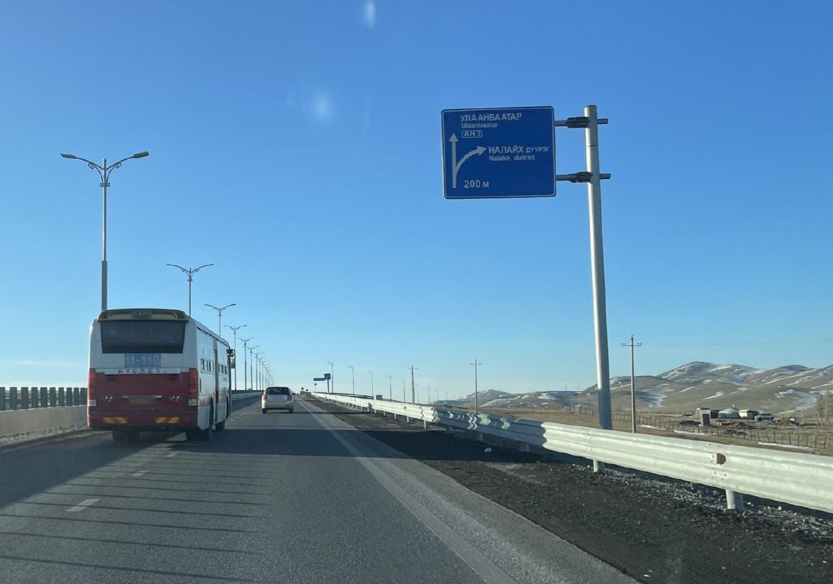 Налайх дүүргийн чиглэлийг заасан цэнхэр тэмдэг бүхий хурдны зам дээр явж буй автобус, суудлын машин