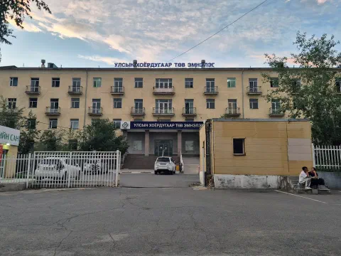 Үүлтэй тэнгэрийн доорх шар өнгийн дөрвөн давхар эмнэлгийн барилга, дээрээ «Улсын хоёрдугаар төв эмнэлэг» бичигтэй, урд талын зогсоол