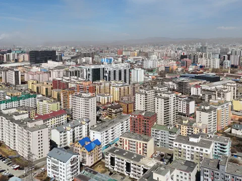 Улаанбаатар хотын Хан-Уул дүүргийн олон давхар орон сууцны хорооллыг агаараас харсан байдал, цаана нь уулс харагдаж буй нь